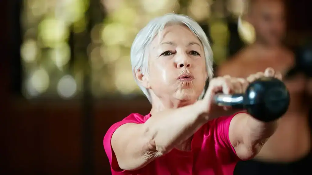 Older woman doing weight training Ashford to help her strength and longevity 