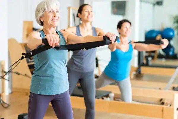 Toning Arms After 60: Empowering Womens Fitness Through Effective Weight Training 2 older woman doing weight training Ashford and resistance in the gym to tone upper arms