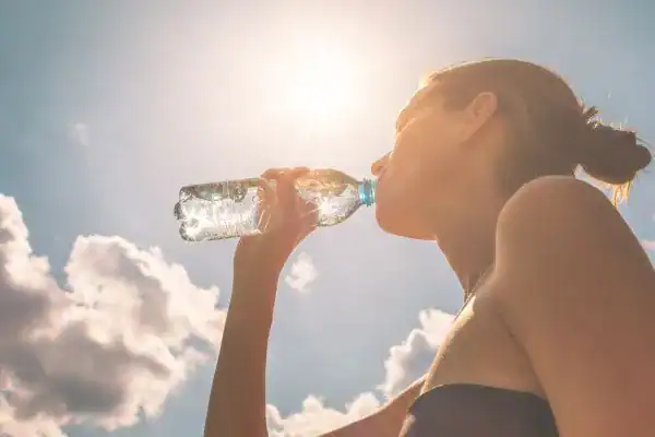 Hydration: The Secret Ingredient for a Toned Stomach and Enhanced Fitness 3 Image of woman drinking water to hydrate Ashford after run.